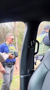 👮 handcuffing a young woman in red and black plaid pants as at least two other agents look on. The agents are wearing tactical vests with "BORDER PATROL" and "FEDERAL AGENT" insignia. | Satiro