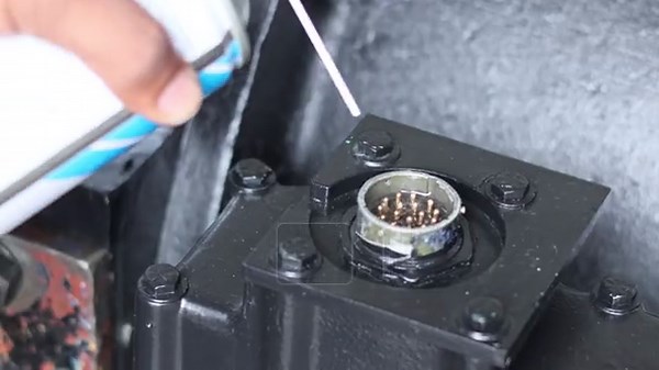 A close-up shot of a technician using a specialized contact cleaner spray to remove dust and oxidation from a multi-pin electrical connector on industrial machinery Stock Video Footage - Alamy