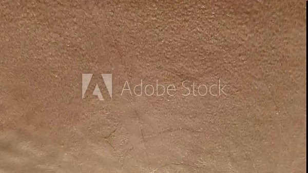 Continuous ocean waves drench a sandy and rocky beach, suitable for use as a dynamic vacation background in creative projects. Stock Video