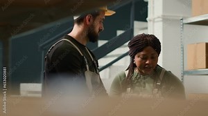 Logistics coordinator using laptop to carry out the logistics of receiving, processing, storing and sending inventory according to purchase orders and shipping schedules in warehouse workplace