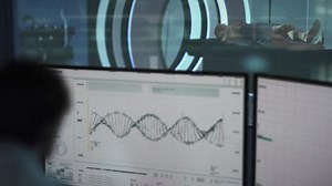 Inside a laboratory. Patient on examination bed while the medical laboratory technician is observing and reading the DNA sequence. Bioinformatics software on a computer's screen. Molecular biology