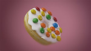 Donut with icing chocolates rotating on a pink background - Free Stock Video