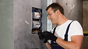 clip-1105451359-electrician-repairing-electrical-box-using-screwdriver ...