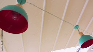 Cafe string chandeliers are swinging in the wind. Chandeliers on a windy day. Cafe string light on the storm