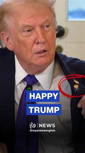 US President Donald Trump displays a "Happy Trump" pin during a press briefing, noting that while the gesture is lighthearted, his focus remains on national objectives. Trump stated that he is "never satisfied" but suggested the country is "getting pretty close" to his administration's goals. | Roya News English