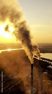 Smoking factory chimney. Plant emits smoke and smog from the pipes at sunset, pollutants enter the atmosphere. Vertical video