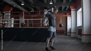 Young man preparing muscles before training. Muscular athlete exercising in gym. Fit man stretching. Professional sportsman warming-up. Full body length portrait
