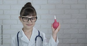 Child with enema. A smiling child play with an enema like a nurse in the room.