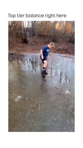 Follow for chocolate 🍫 on Instagram: "This video captures a painful yet comical mishap as a young boy tests the strength of thin ice on a frozen puddle. The Subject A young boy wearing a blue T-shirt, black shorts, and galaxy-patterned socks is standing on a thin layer of ice covering a large puddle. The scene is set outdoors in a wooded area with fallen leaves scattered across the ground and trees visible in the background. The Mechanism The boy cautiously steps onto the ice and begins to shif