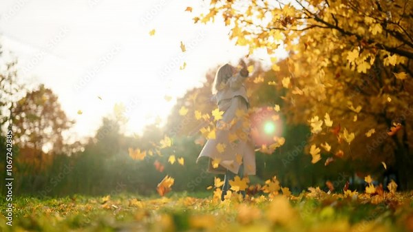 Picturesque landscape in forest in autumn, woman whirling in falling foliage. Happy woman enjoying sunny weather in beautiful fall day, good mood and positivity, casual cloth style for walk in nature