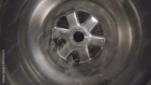Water vortex shot underwater extreme macro close up of a laundry sink plug hole as water empties with a large vortex that forms around the lens. Lens focus on above drain hole on vortex.
