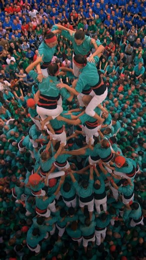 The Catalonian tradition of creating human towers called castells stretches back centuries and has evolved into a competitive sport. Hundreds of people come together to act as building blocks for these temporary monuments to teamwork and cooperation. #OneStrangeRock is now streaming on Disney . | National Geographic History