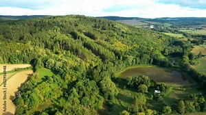 A pond in the middle of the woods. Drone flight over rural landscape. The Bohemian forest Hills on the Czech countryside. Central Europe.