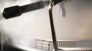 A close-up of a coffee machine steaming intensely, the camera fixes on the steam wand