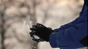Packing a Snowball Tilt and Throw. camera follows the action of someone packing a snowball and throwing it away from the camera. slow motion
