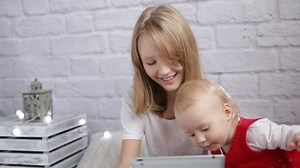 Girls playing on the tablet at home