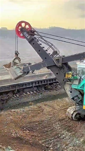 Worker ensures clean loading during mining railcar task