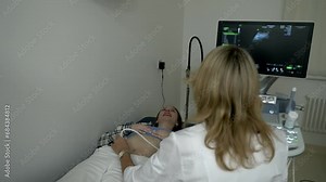 Doctor Examining Woman By Checking Belly With Ultrasound Device. Woman Lays Back As Doctor Performs Examination. Ultrasound Images On Medical Equipment Screen. Checking Health Of Baby In Woman's Womb