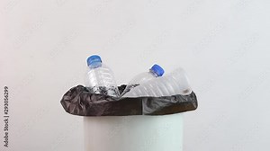 Hand throwing empty plastic water bottle into recycling bin, environmental protection. Zero waste concept.