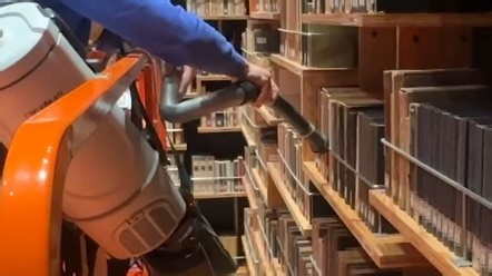 图书馆的员工正在清理藏书中的灰尘