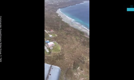 US Navy helicopter flies over typhoon damage during relief mission