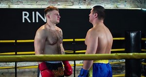 Two boxers face-off looks starts fight touch gloves each other before combat 4k video in boxing ring. Close-up view
