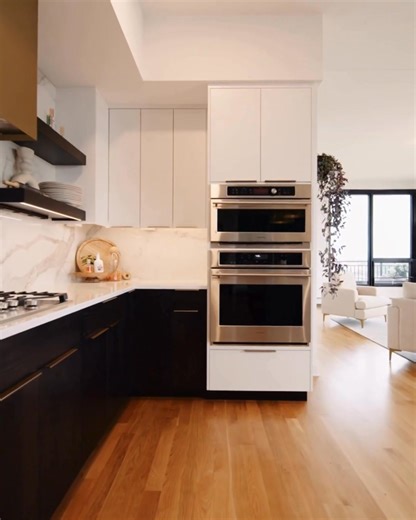 We love the contrast of dark cabinets with bright white tile and warm wood floors. The open shelving adds both function and warmth to this kitchen. If you're planning a kitchen renovation, call or text me (Vince) at 416-562-2387. | Kitchen & Bath Guys