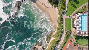 This 4K aerial shot beautifully captures the tranquil morning ambiance of Laguna Beach, with its pristine shoreline, vibrant waters, and luxurious coastal properties under the warm sunrise light