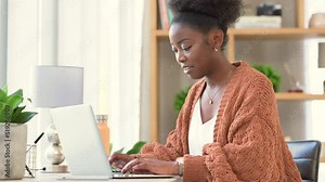 A remote student typing and doing research for an essay or article on a laptop. Female university student writing notes on a computer at her desk while studying for college exams online at home