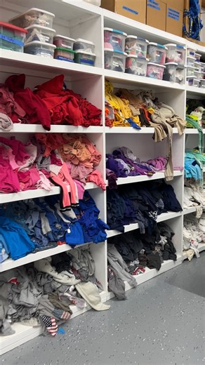 Take a peek behind the scenes at our quilt studio. This is our sewing and storage area, where shelves of T-shirts are organized by color and theme such as Christmas, Harley-Davidson, Halloween, Mickey Mouse, unicorns, and more. When it’s time to design another ultramodern quilt, I head back here to hand-pick the perfect shirts. #TshirtQuilt #UltramodernQuilt #QuiltStudio #QuiltStorage #QuiltDesign #TooCoolTshirtQuilts #QuiltingLife #tshirts | Too Cool T-Shirt Quilts