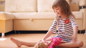 Little girl playing with a dolls