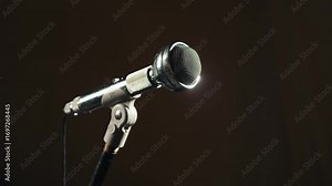 Retro microphone on studio or stage, macro of check sound, hand touch microphone.