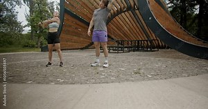 Three friends stretch together before a workout in a park. They are wearing active wear and sneakers, enjoying the outdoors.