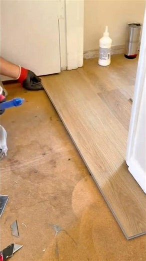Installing interlocking vinyl planks precisely around the door frame for a seamless finish