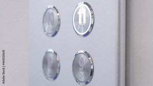 Slow motion: woman finger pressing elevator button of eleventh floor on lift control panel at mall, hotel or business center - close up view. Technology and transportation concept
