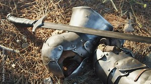 An iron sword forged based on medieval technology and protective combat gauntlets lie on the ground. Knight armour