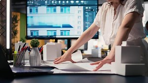 Close up of developer does city planning session with blueprints plan for layout details and zoning regulations, focusing on site preparation for housing. Urban development. Camera A.