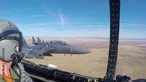 POV from inside of a fighter jet as it flies in formation.