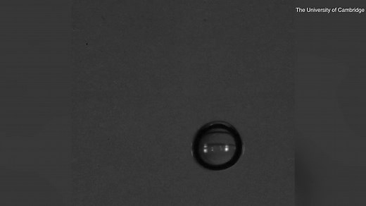 Ultra slow-motion video shows a water droplet hitting liquid surface