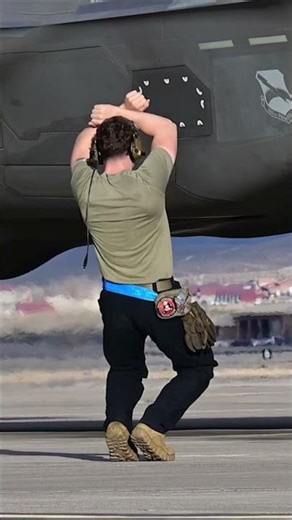 Ground Crew Hand Signals Guide Fighter Jet to Parking
