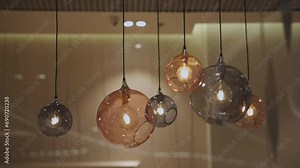 round ceiling lights with cords. Round ceiling lamp, modern hanging lighting fixtures. many round ceiling lamps hang at different height. horizontal orientation video, close-up