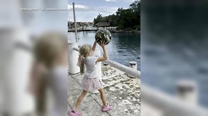 Little girl plays catch with a dolphin
