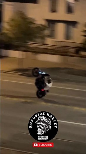 American Biker Stunt Eith Harley Davidson Dyna Wheelie On The Street Night
