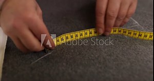 Seamstress uses chalk and measuring tool to mark precise lines