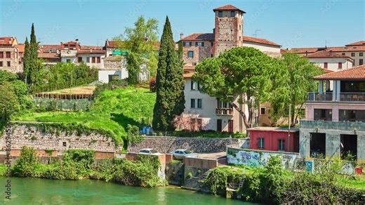 BASSANO DEL GRAPPA, ITALY - APRIL 19 2018: Brenta River and ancient stone buildings in Bassano del Grappa, Vicenza province of region of Veneto, in northern Italy.