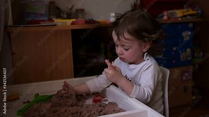 Girl playing with kinetic sand. Early child development. The birth of an idea and its revision in a future startup.