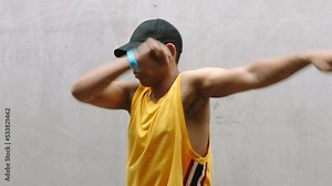 Professional dancer man, dance and hip hop in expressive moves against a grey wall background. Fit, active and energetic male dancing in competitive practice and training for freestyle competition