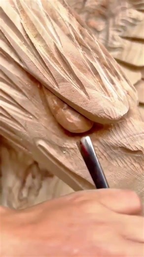 A detailed master woodcarver uses precise hand gouges to meticulously define