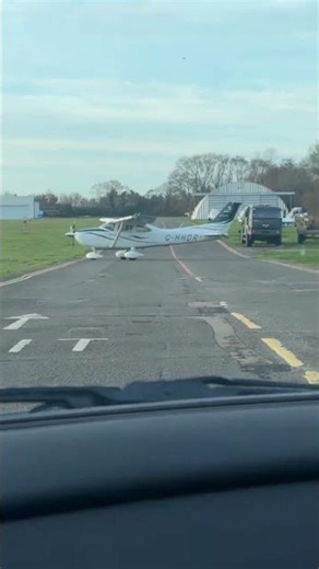 Airplane crossing in front of Aston Martin V12 Vantage