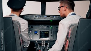 pilots in the cockpit of the plane near the control panel with a tablet in their hands discuss the route before the start of the flight simulator